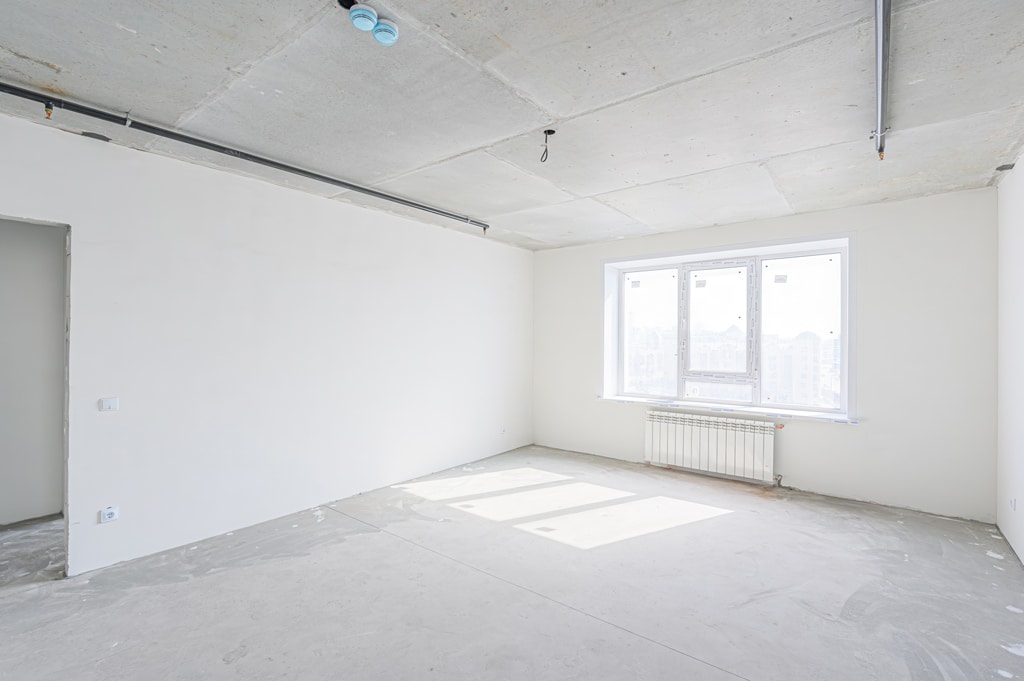 empty, unfinished room with white walls and a concrete floor. Pi