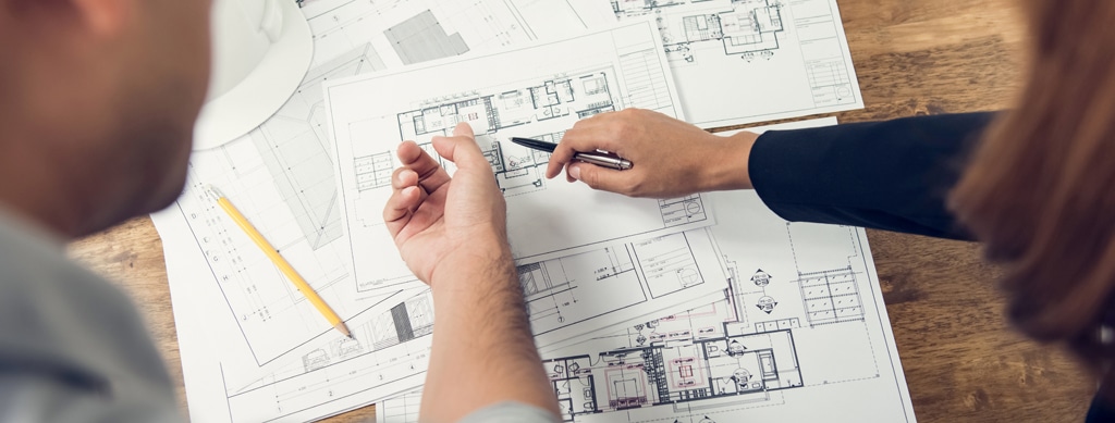 Engineer and architect discussing about blueprint layout design
